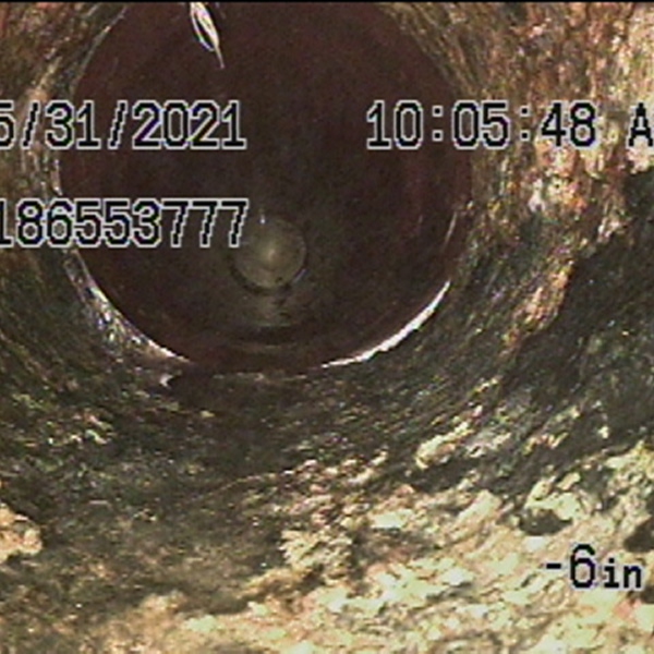 Vue d'un drain bouché avec accumulation de saleté et de débris à l'intérieur